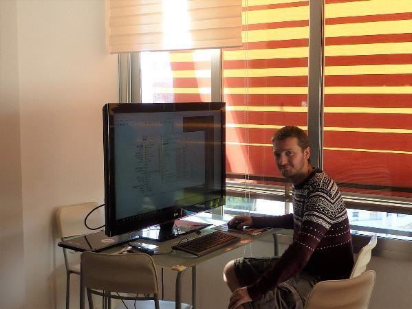 Pete using a massive TV screen to enable him to see the files much easier when proofreading a manuscript